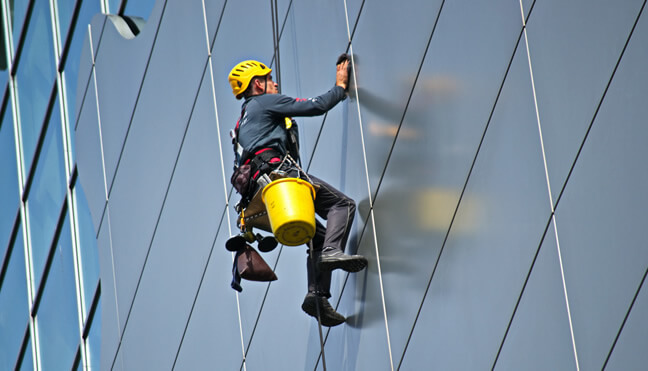 Hanging worker window washing a high rise building